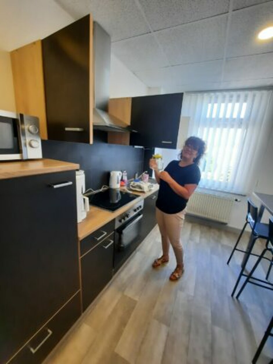 Küche mit Sitzgelegenheiten & Küchenzeile, Herd mit Backofen, Kühlschrank, persönliches Tiefkühlfach, Mikrowelle, Geschirrspüler, diversen Küchenutensilien